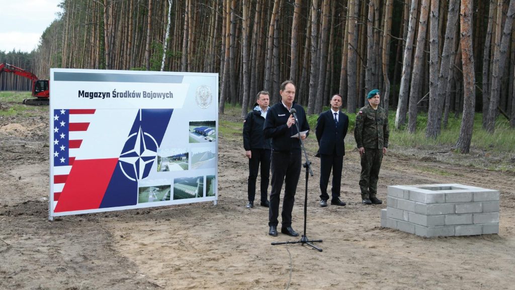 U.S. Ambassador to Poland Mark Brzezinski gives remarks at a groundbreaking ceremony for a Munitions Storage Area being constructed in Powidz, Poland, June 2, 2022, where he was joined by Polish Minister of National Defense Mariusz Błaszczak, NATO Investment Committee Chair Emanuele Meli, and Plenipotentiary to the Minister of Defense for the Enhanced Defense Cooperation Agreement, Polish Brig. Gen. Dariusz Mendrala. The ceremony marked the beginning of the Poland Provided Infrastructure program, which provides a mechanism for sharing the costs for U.S. forces in Poland. Infrastructure projects are funded by Poland and are designed and constructed to meet U.S. requirements for use by U.S. forces operating in Poland. For its part, the United States will continue to bear the costs of training, equipping, deploying, and employment of U.S. forces in the country.