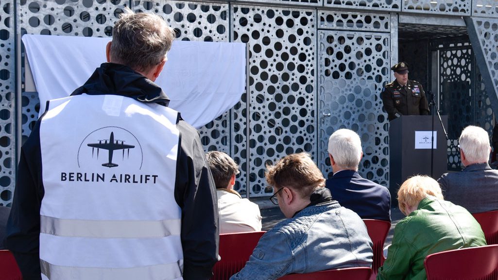 U.S. Army Corps of Engineers, Europe District Commander Col. Dan Kent speaks at a ceremony dedicating the new air traffic control tower on the Clay Kaserne portion of U.S. Army Garrison Wiesbaden the Berlin Airlift’s “Candy Bomber” – the late Col. Gail S. Halvorsen