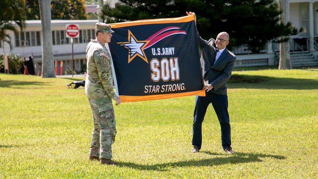 Lt. Col. Christopher “Ryan” Pevey, Honolulu District commander, receives the Safety and Occupational Health Star flag from Troy Larson, Headquarters U.S. Army Corps of Engineers Safety and Occupational Health Manager during a ceremony to present the prestigious Army Safety and Occupational Health Star Award to the Honolulu District, U.S. Army Corps of Engineers on Fort Shafter June 28, 2024. USACE PHOTO BY CORTLAND HENDERSON