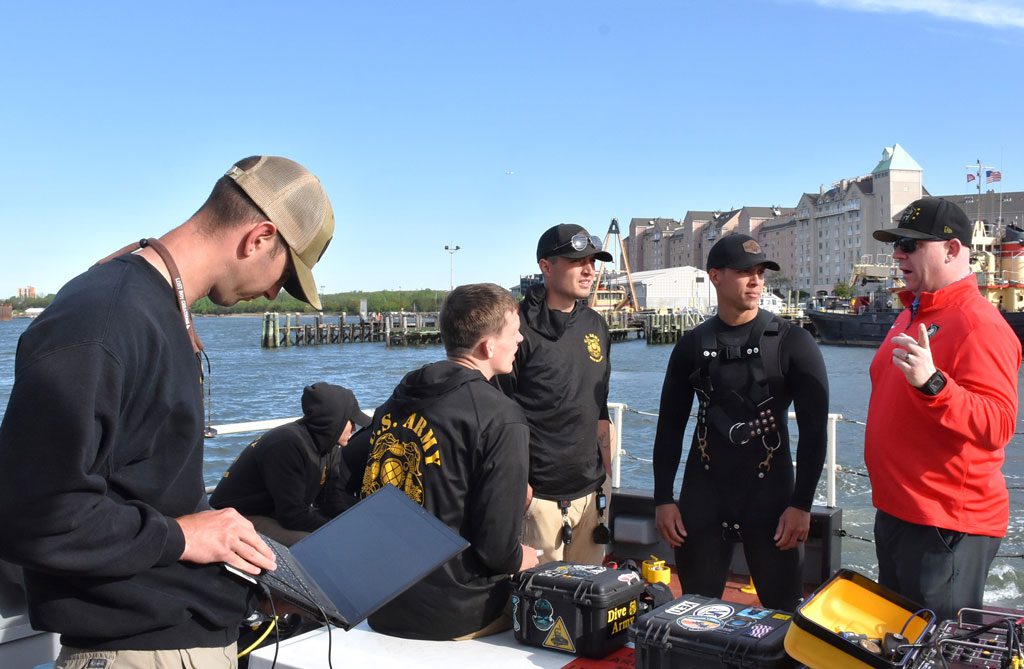A member of the U.S. Army’s 86th Engineer Dive Detachment monitors information as team members discuss operations before diving into New York-New Jersey Harbor.