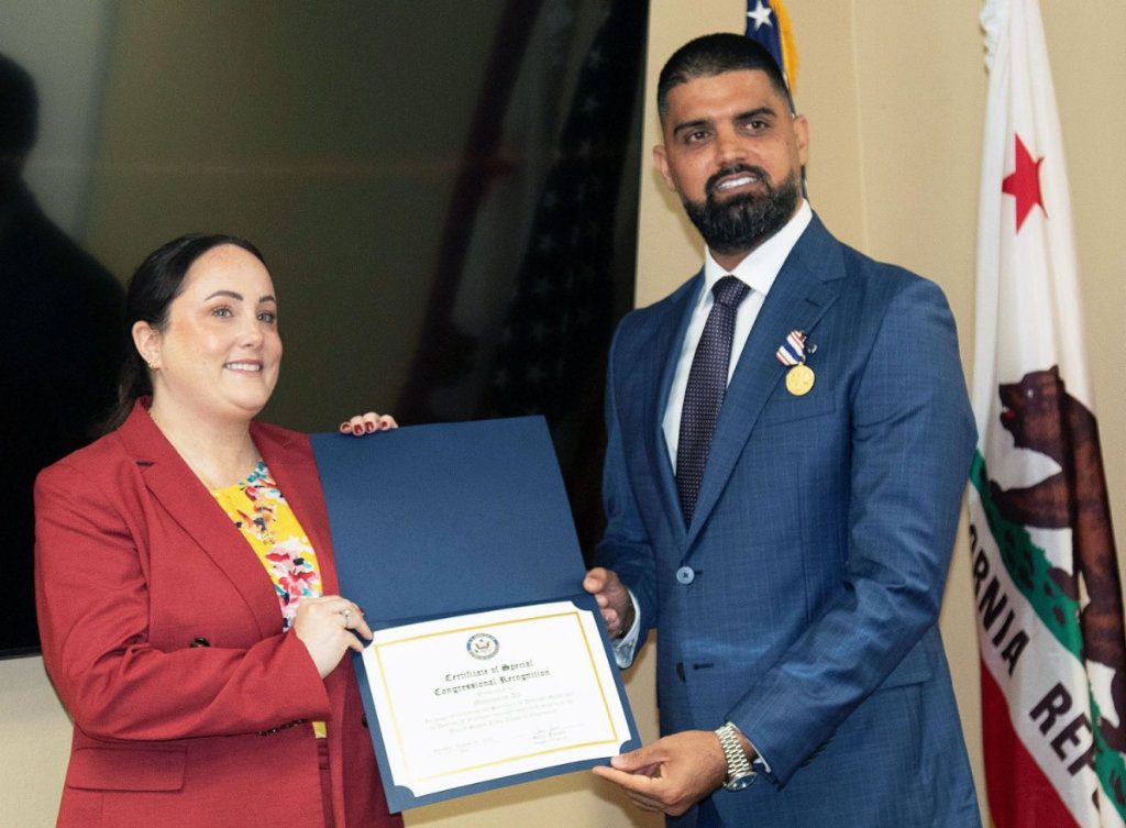 Kate Needham-Cano, senior community representative and military and veterans Liaison for Rep. Sara Jacobs, congresswoman for California’s 51st Congressional District, left, presents Mohannad Ali of San Diego, right, with a Certificate of Special Congressional Recognition during an Aug. 26 ceremony honoring Ali in San Diego, Calif. (Photo by Dena O’Dell, U.S. Army Corps of Engineers Los Angeles District) (Photo Credit: Courtesy)