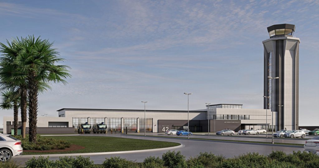 Architectural rendering of a modern airfield complex featuring a tall, concrete air traffic control tower, an air operations facility, and a fire station with large glass bay doors under a bright blue sky.