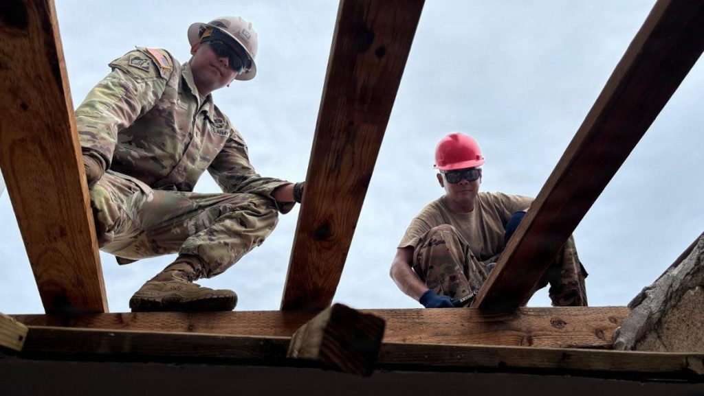 Chief Warrant Officer 3 Khristian Lee Viray, a temporary roofing planner with the 411th Engineer Battalion, speaks with soldiers during the STRONG Roof mission in Saipan, Commonwealth of the Northern Mariana Islands, following Super Typhoon Sinlaku. Viray, who survived typhoons, floods and volcanic eruptions growing up in the Philippines, now leads Army Reserve engineer teams helping island families recover by installing temporary roofs on storm-damaged homes as part of Defense Support of Civil Authorities operations in coordination with FEMA and the U.S. Army Corps of Engineers. USACE PHOTO BY PACO HAMM
