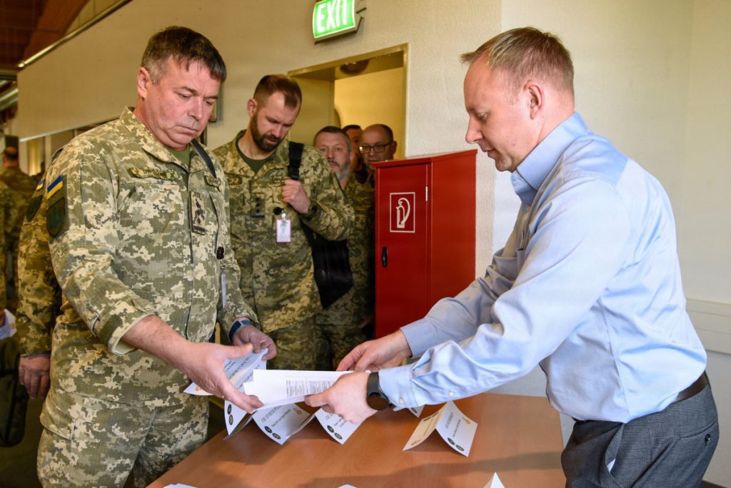 U.S. Army Corps of Engineers, Europe District Chief of Plans Matt Mollet passes out reading materials to officers from Ukraine’s State Special Transport Service for the Strategic Program and Project Delivery workshop April 27 at McCully Barracks in Wackernheim, Germany. The goal of this workshop was to empower Ukraine to be able to better lead aspects of its own recovery by familiarizing SSTS representatives with advanced approaches to implementing large-scale infrastructure projects that will support the recovery and protection of critical infrastructure of Ukraine. U.S. ARMY PHOTO HANNAH MITCHELL