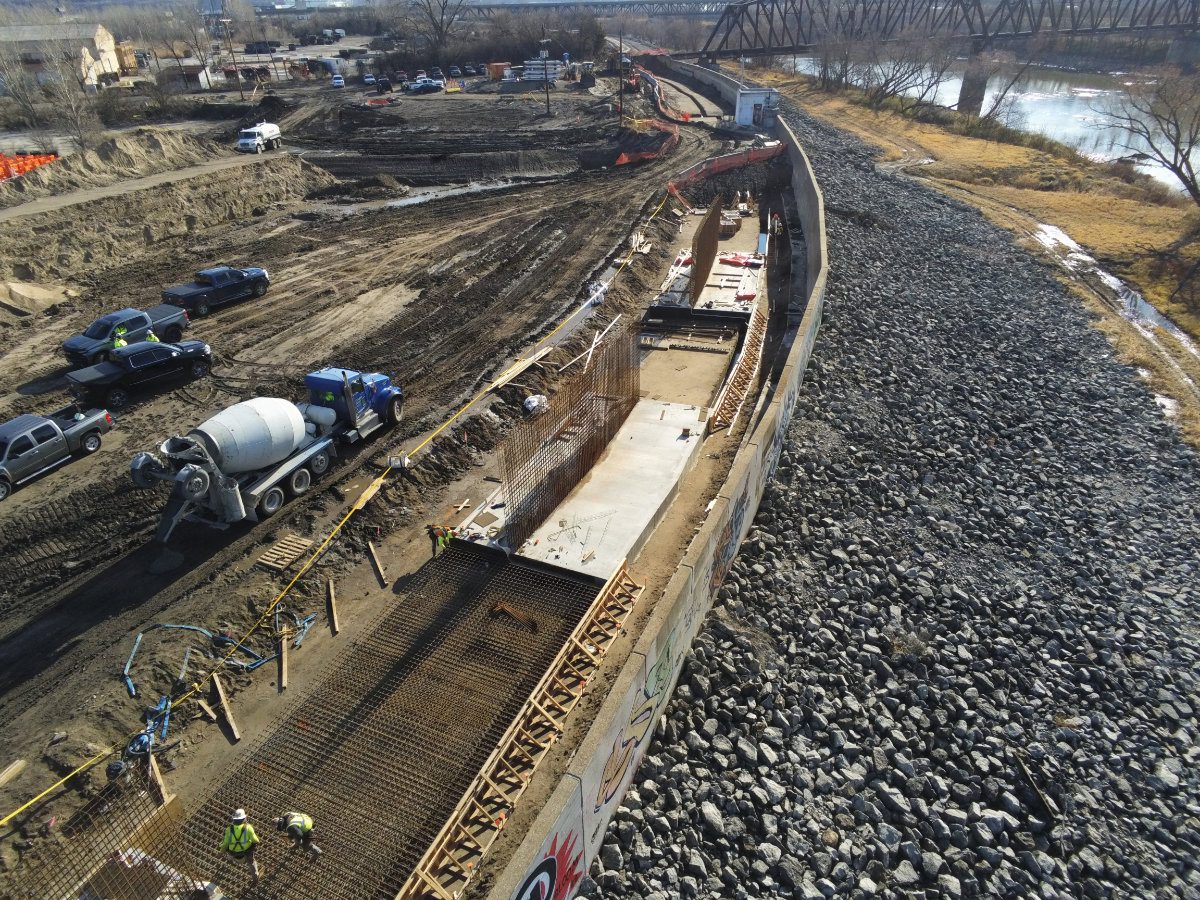 Ironworkers assembling a dense steel rebar grid in preparation for a structural concrete floodwall pour.