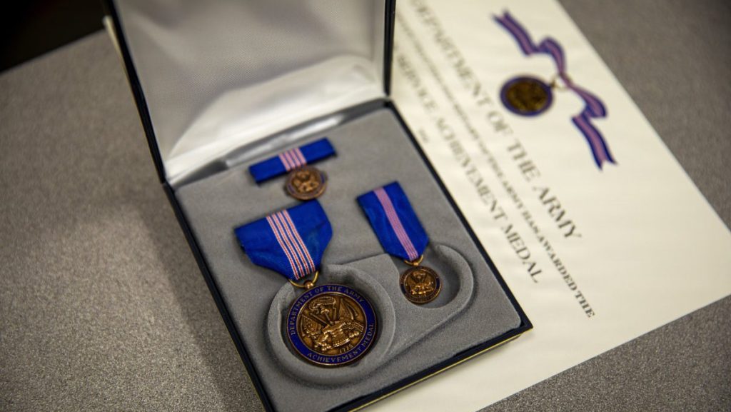 A Department of the Army Civilian Service Achievement Medal set displayed inside an open presentation case next to an official award certificate.