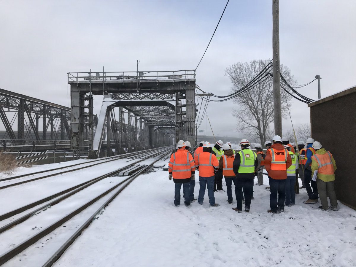 A USACE engineer conducts a winter site inspection along a snow-covered rail bridge and levee structure in Kansas City.