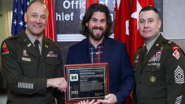 Mobile District Program Manager, Jesse Hall (center), receives the 2025 USACE Coastal Navigation Program Manager of the Year Award from the 56th Chief of Engineers and Commanding General of the U.S. Army Corps of Engineers Lt. Gen. William H. "Butch" Graham, Jr. and Command Sergeant Major Douglas Galick at a ceremony held at the USACE headquarters building in Washington, D.C. on January 23, 2026. U.S. ARMY PHOTO BY DIANE RIVERA ESTELLA